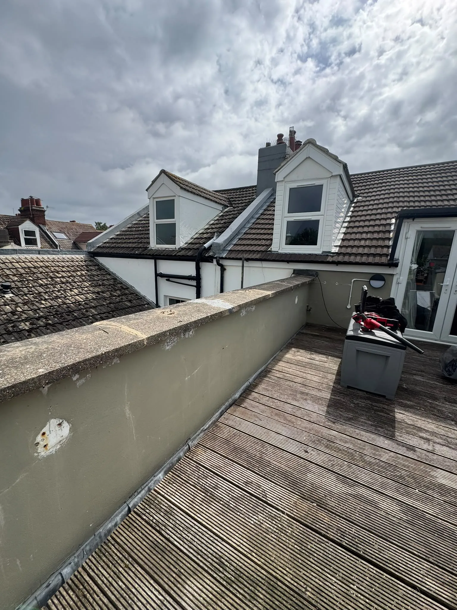 Balcony parapet wall on a Brighton property with the original coping stones in place before works — water was getting in through the coping joints