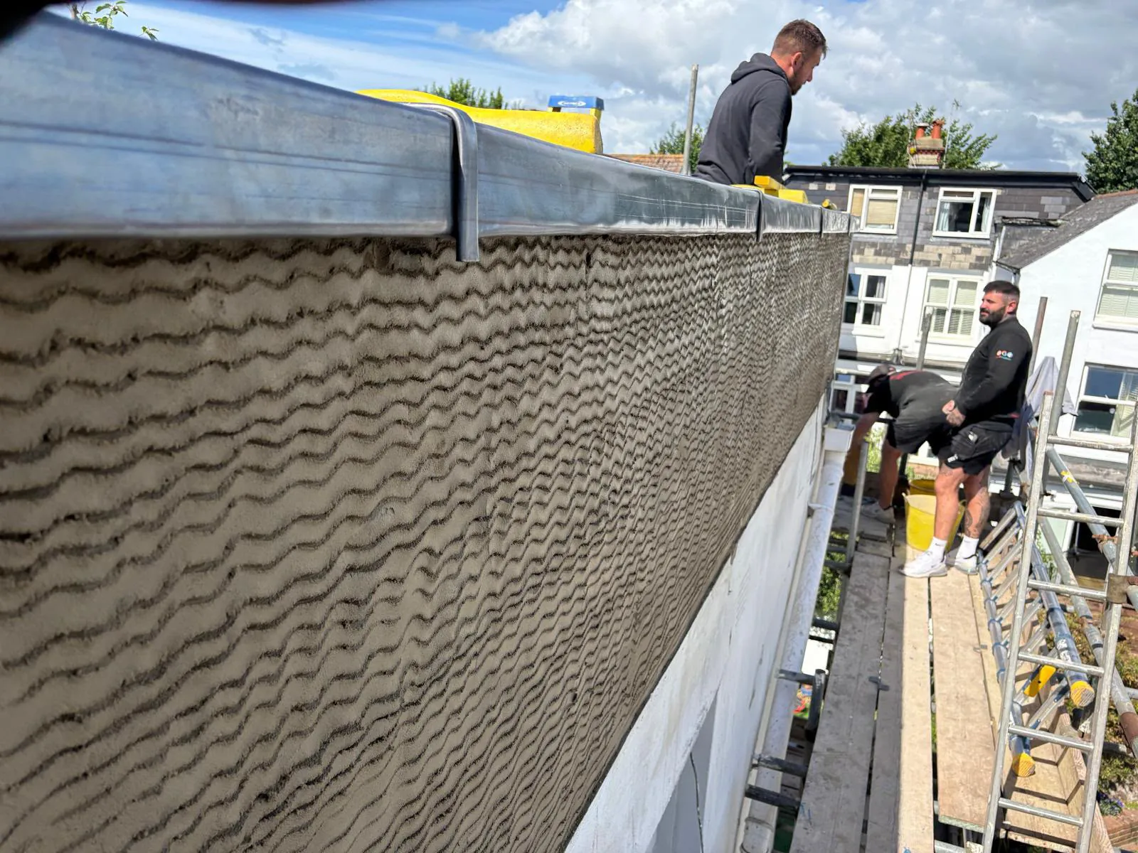 Rendered outer face of the balcony wall with the new lead capping fitted along the top