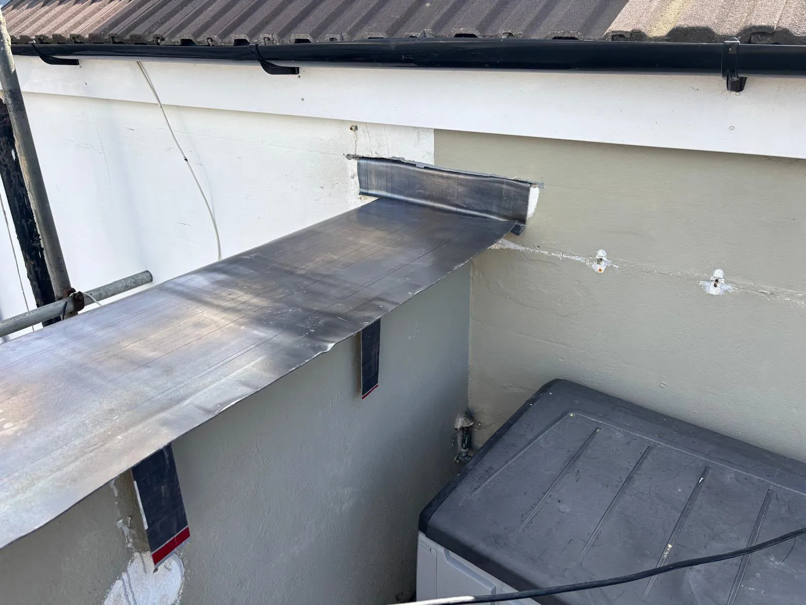 Code 5 lead capping being fitted on the balcony wall with fixing clips along the face