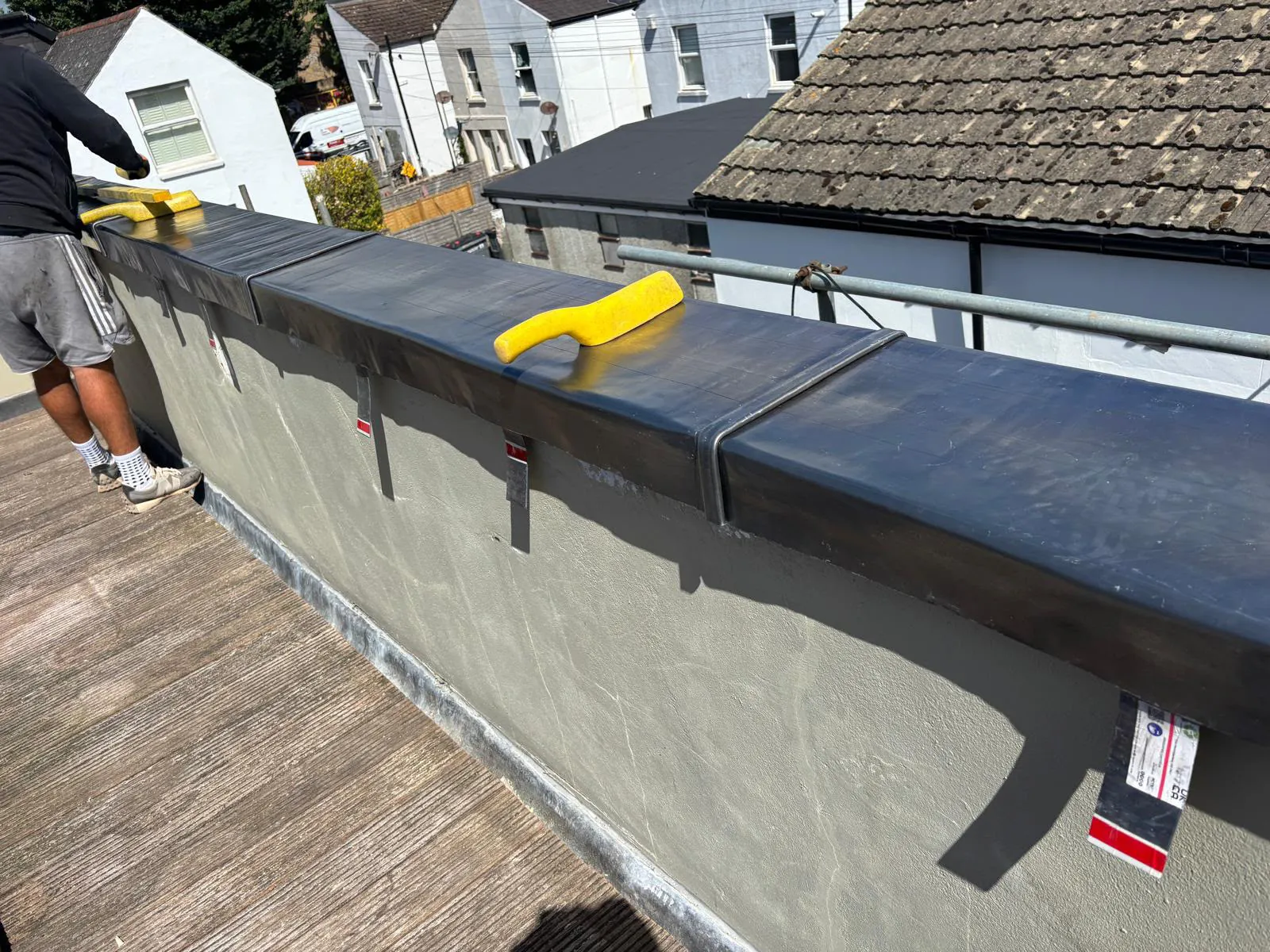 Code 5 lead being dressed over the marine ply base on the balcony parapet wall