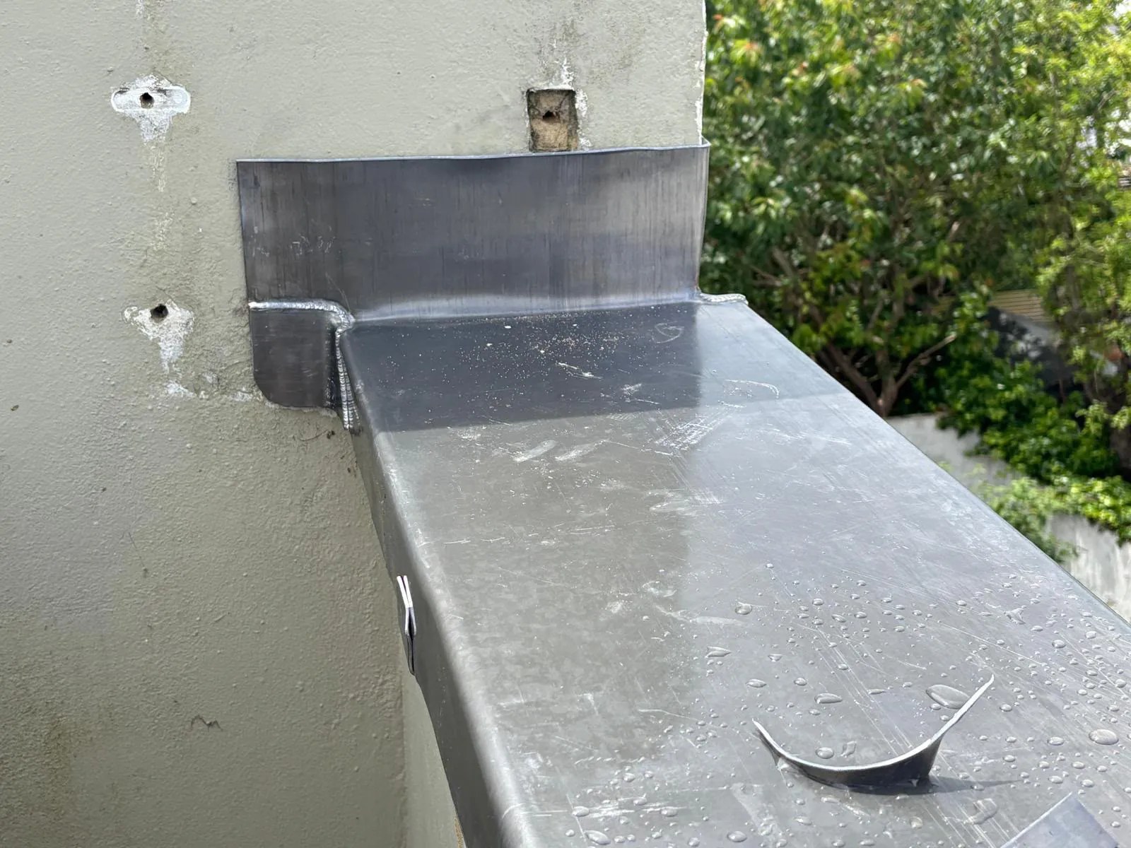 Welded lead upstand where the wall capping meets the adjoining wall of the house