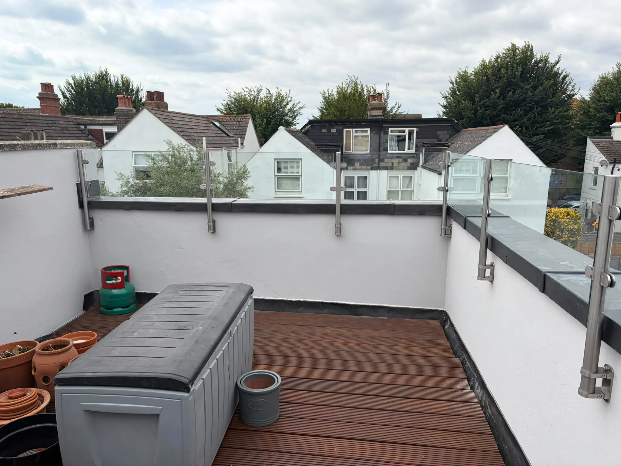 Finished balcony parapet with weatherproof lead capping, glass balustrade back in place and decking clear