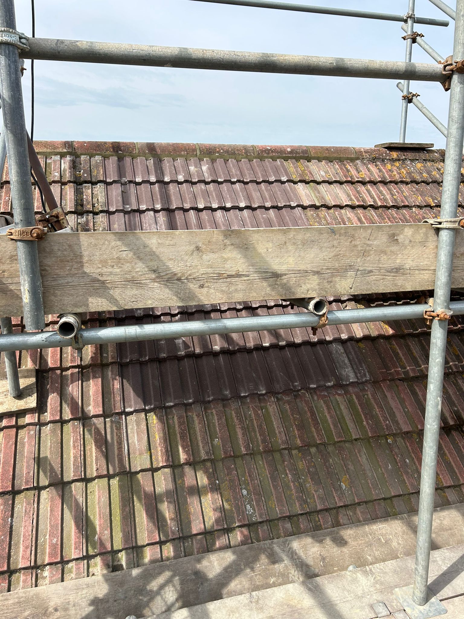 Chimney void area tiled over and blended into the surrounding roof — new tile courses run to the ridge with sand and cement applied to the ridgeline