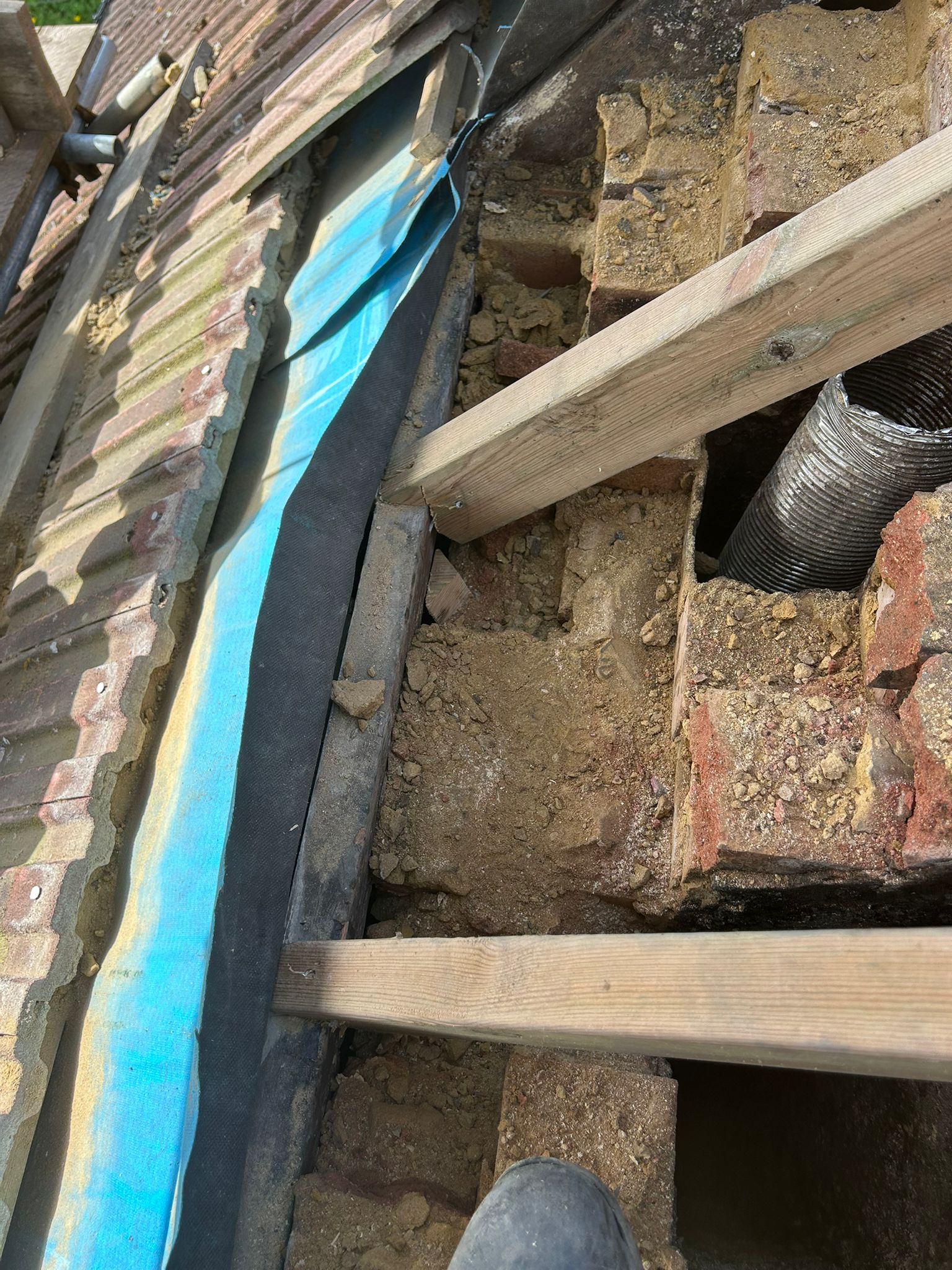 New softwood rafter fitted into the chimney void alongside the retained existing rafters — new timber sized and seated correctly to carry the tiling load